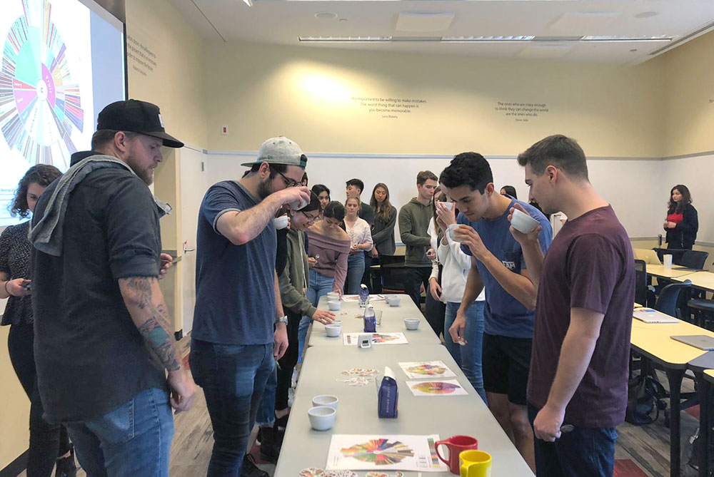 Students smelling cups of coffee